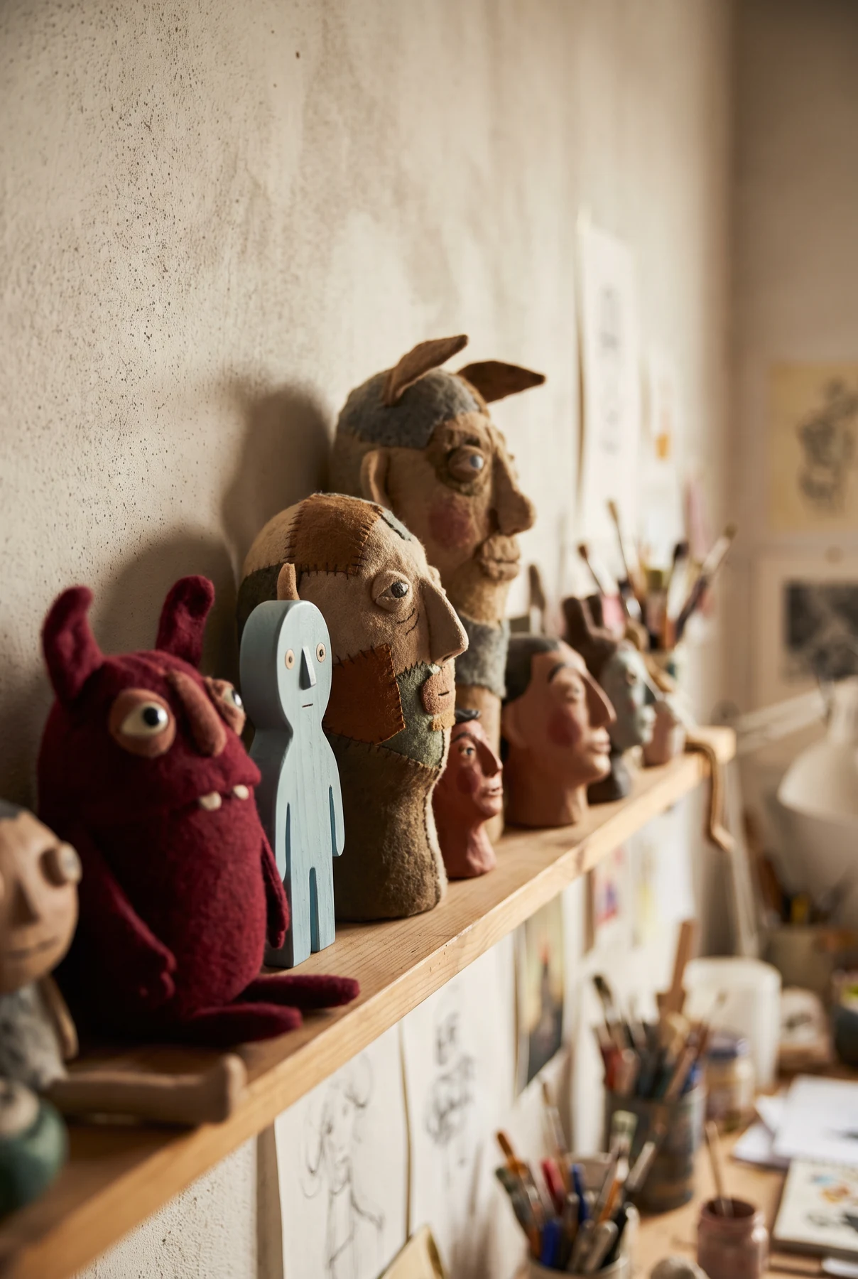 Handmade puppet heads on a studio shelf